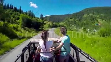 一对年轻夫妇坐着吉普车在路上，山顶开着。 那家伙和那女孩正乘着一辆小卡车旅行